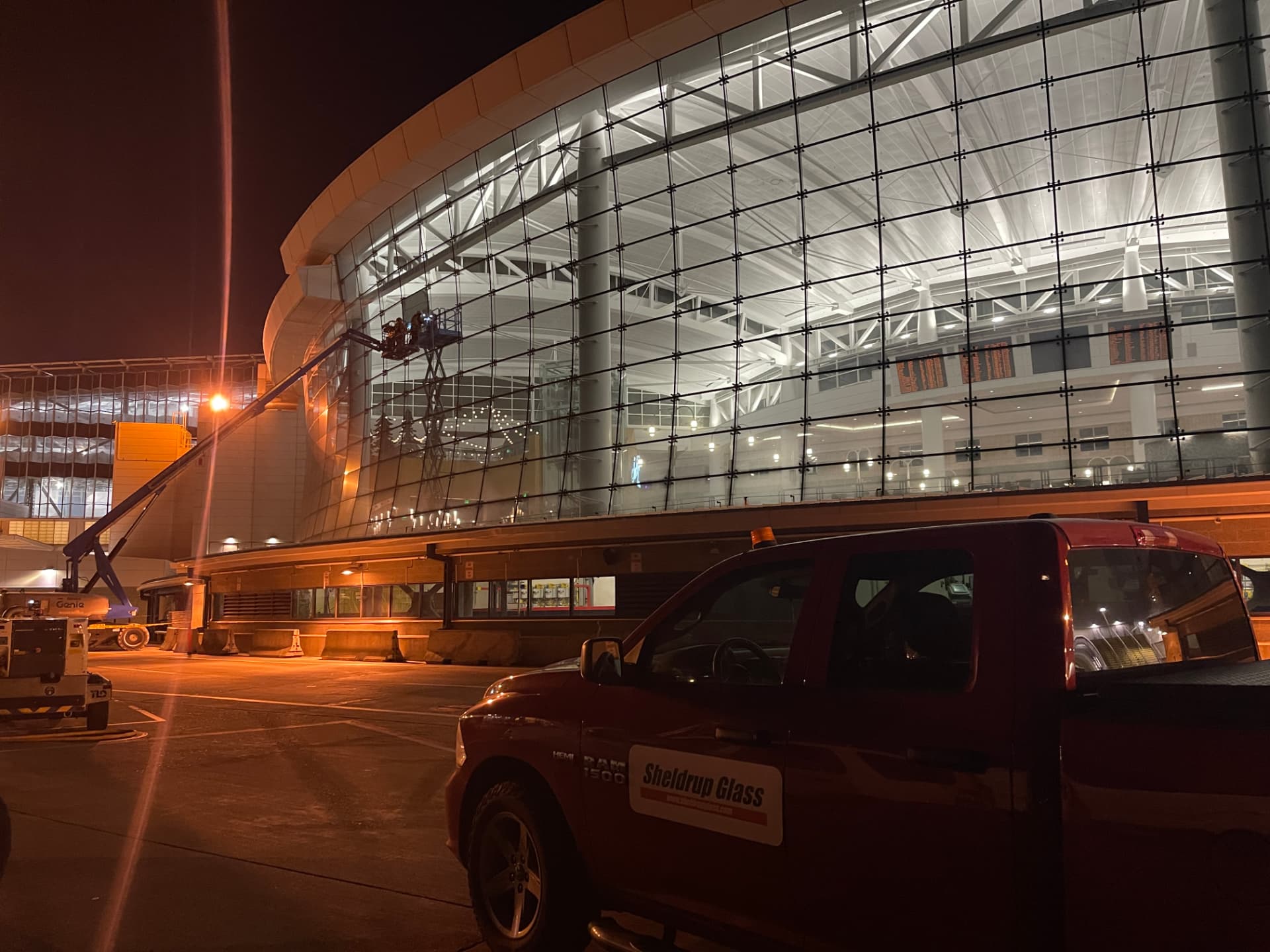 Night installation of a curved glass curtain wall with a Sheldrup Glass truck in the foreground
